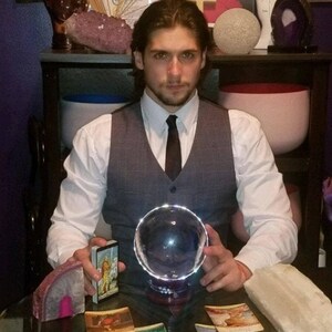 In-depth tarot card reading session led by Psychic Derek with raw quartz crystals, flickering candles, and sacred spiritual tools set on a dark altar cloth.