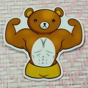 May include: A sticker featuring a cartoon bear with brown fur, yellow ears, and a white belly. The bear is flexing its muscular arms and wearing yellow shorts. The sticker has a white border.