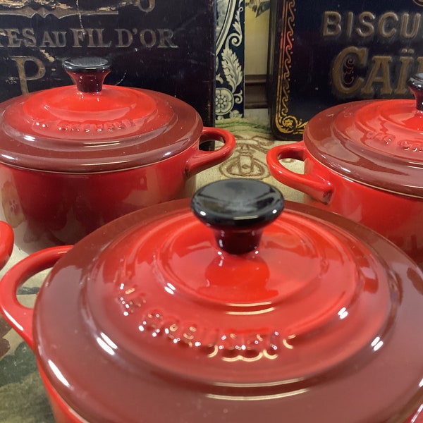 Set van 2 Franse Le Creuset rode keramische kleine braadpannen, 2 rode Le Creuset individuele steengoed cocottes, 2 Le Creuset keramische dekselschotels.