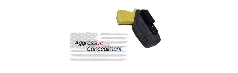 May include: A black holster with a yellow gun inside. The holster has a clip on the back and a textured surface. The text "Aggressive Concealment" is visible in the background.