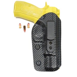 May include: A black carbon fiber gun holster with a black clip and a yellow handgun. The holster has several screws holding it together.