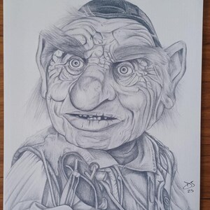 May include: Pencil drawing of a puppet-like character with a wrinkled face, large nose, and intense eyes. The character wears a hat and vest, with visible details in the shading and texture. Signed "DS 25" in the bottom right corner.