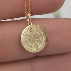 Compass engraved, circular,
solid gold pendant 14k,
the size is 0,5 iches / 12,7 millimeter.
Thickness 0,5 milimiters.
The hoop on top is circular and gold as well.
 The finish of the pendant in shinny.