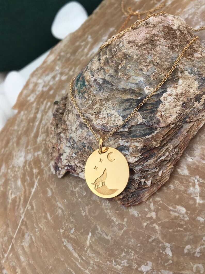 Wolf necklace engraved, circular,
solid gold pendant 14k,
the size is 0,5 iches / 12,7 millimeter.
Thickness 0,5 milimiters.
The hoop on top is circular and gold as well.
 The finish of the pendant in shinny.