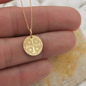 Jerusalim cross engraved, circular,
solid gold pendant 14k,
the size is 0,5 iches / 12,7 millimeter.
Thickness 0,5 milimiters.
The hoop on top is circular and gold as well.
 The finish of the pendant in shinny.