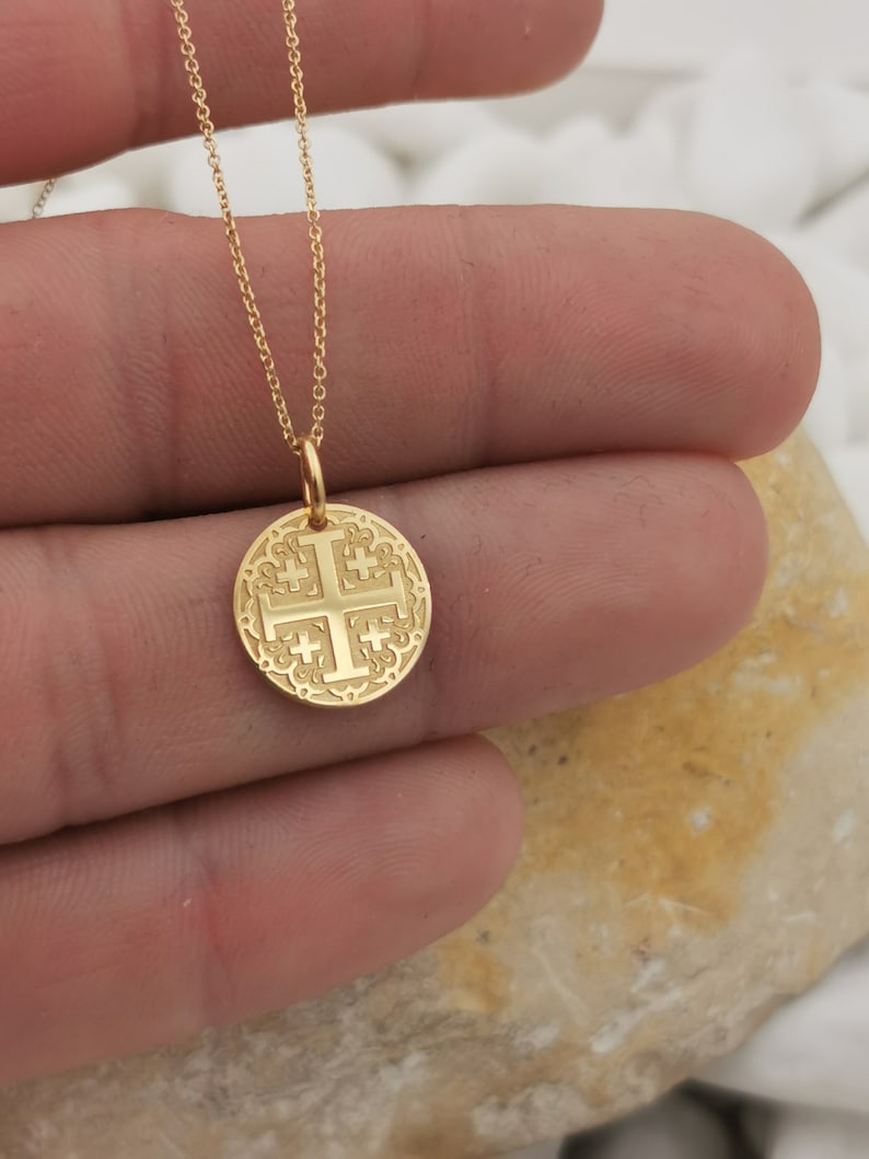 Jerusalim cross engraved, circular,
solid gold pendant 14k,
the size is 0,5 iches / 12,7 millimeter.
Thickness 0,5 milimiters.
The hoop on top is circular and gold as well.
 The finish of the pendant in shinny.