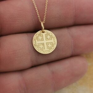 Jerusalim cross engraved, circular,
solid gold pendant 14k,
the size is 0,5 iches / 12,7 millimeter.
Thickness 0,5 milimiters.
The hoop on top is circular and gold as well.
 The finish of the pendant in shinny.