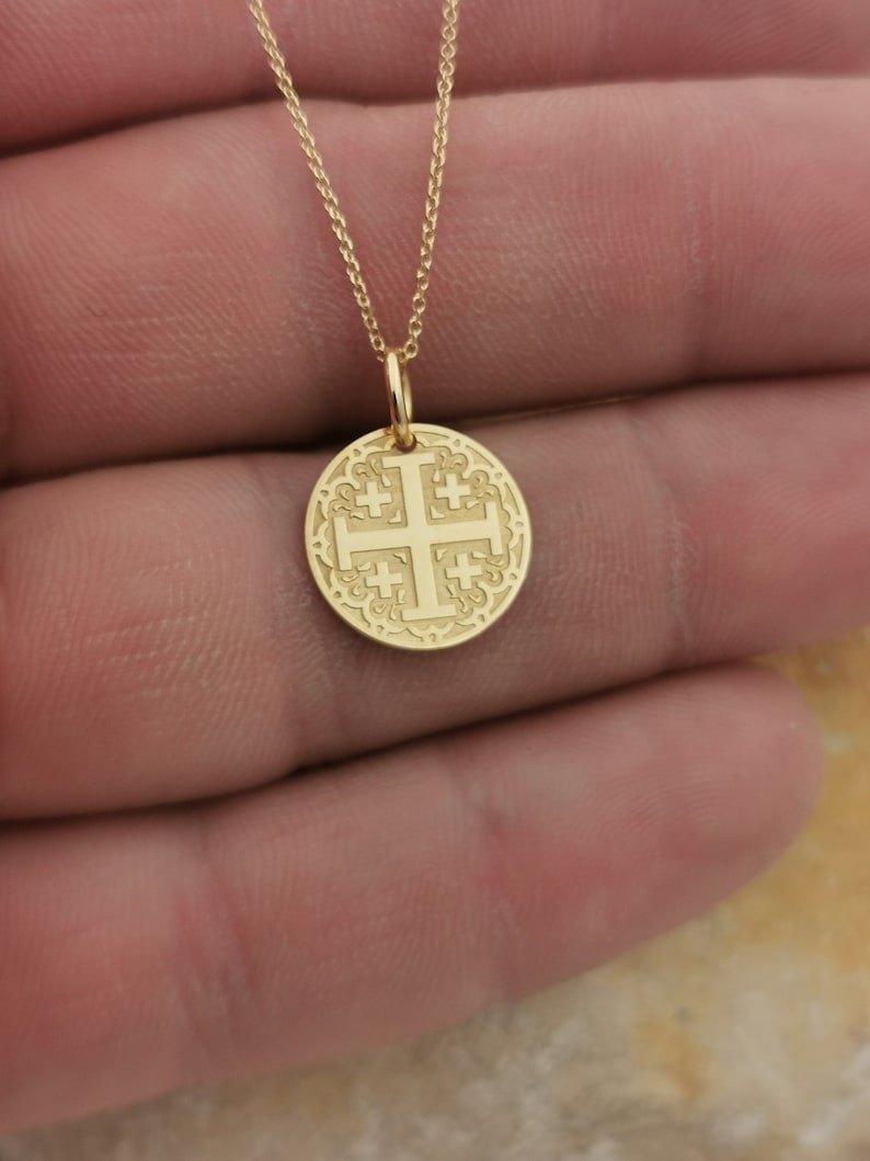 Jerusalim cross engraved, circular,
solid gold pendant 14k,
the size is 0,5 iches / 12,7 millimeter.
Thickness 0,5 milimiters.
The hoop on top is circular and gold as well.
 The finish of the pendant in shinny.