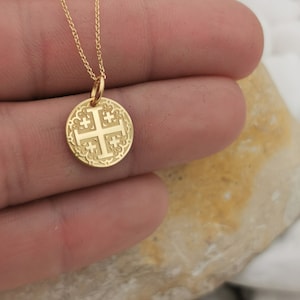 Jerusalim cross engraved, circular,
solid gold pendant 14k,
the size is 0,5 iches / 12,7 millimeter.
Thickness 0,5 milimiters.
The hoop on top is circular and gold as well.
 The finish of the pendant in shinny.