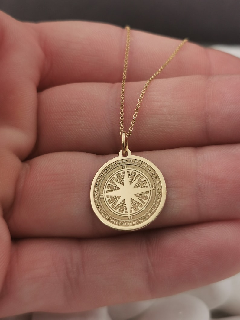 Compass engraved, circular,
solid gold pendant 14k,
the size is 0,75 iches / 19,1 millimeter.
Thickness 0,5 milimiters.
The hoop on top is circular and gold as well.
 The finish of the pendant in shinny.