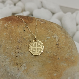 Jerusalim cross engraved, circular,
solid gold pendant 14k,
the size is 0,5 iches / 12,7 millimeter.
Thickness 0,5 milimiters.
The hoop on top is circular and gold as well.
 The finish of the pendant in shinny.