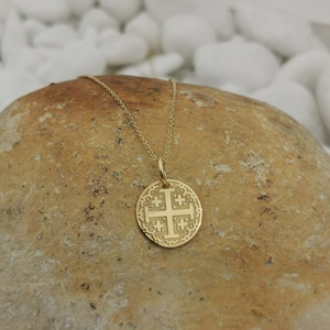 Jerusalim cross engraved, circular,
solid gold pendant 14k,
the size is 0,5 iches / 12,7 millimeter.
Thickness 0,5 milimiters.
The hoop on top is circular and gold as well.
 The finish of the pendant in shinny.