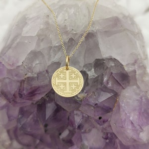 Jerusalim cross engraved, circular,
solid gold pendant 14k,
the size is 0,5 iches / 12,7 millimeter.
Thickness 0,5 milimiters.
The hoop on top is circular and gold as well.
 The finish of the pendant in shinny.