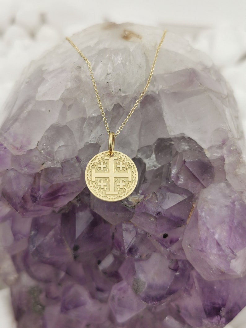 Jerusalim cross engraved, circular,
solid gold pendant 14k,
the size is 0,5 iches / 12,7 millimeter.
Thickness 0,5 milimiters.
The hoop on top is circular and gold as well.
 The finish of the pendant in shinny.