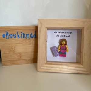 May include: A framed picture featuring a Lego figurine of a woman holding a boombox. The text in the picture reads "On Wednesdays we work out".