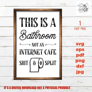 May include: A white sign with black text that reads "This is a Bathroom Not an Internet Cafe Shit & Split" with a toilet paper roll graphic. The sign is framed in wood and is hanging on a white wood wall.
