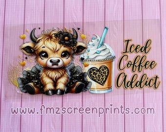 May include: A cute cartoon cow wearing a black dress with gold glitter and a black bow. The cow is holding a cup of iced coffee with a heart-shaped design and the text "Iced Coffee Addict".