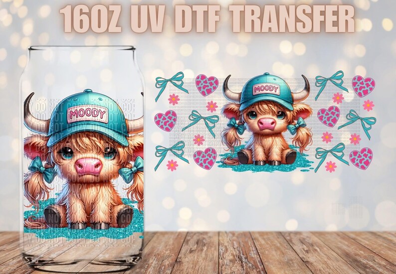 Puede incluir: Un transfer UV DTF de 16 oz con una vaca de las Tierras Altas de dibujos animados que lleva un sombrero azul con la palabra "MOODY" en &eacute;l. La vaca est&aacute; rodeada de corazones y flores rosas y azules.