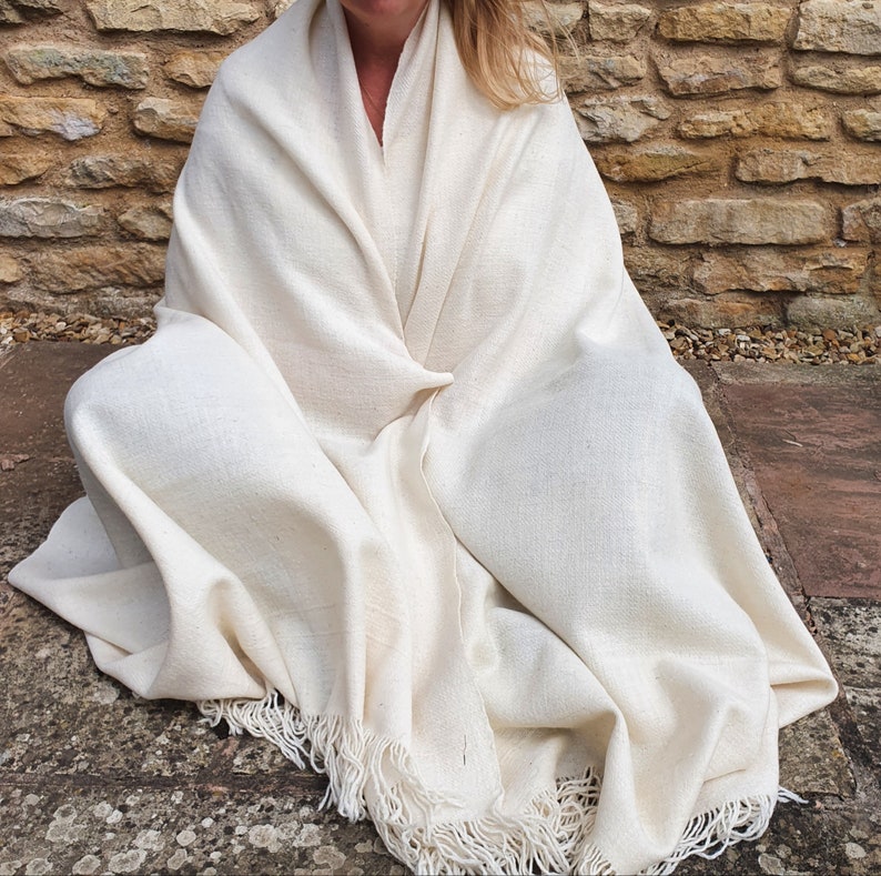 Himalayan Meditation shawl in pure sheeps wool. Each shawl is individually handloomed using local handspun sheeps wool. Door to the Himalayas works directly and sustainably with the Botiya Tribe to bring these authentic, thick, warm meditation shawls to market.
Large meditation shawls are available in unbleached white and natural grey wool.