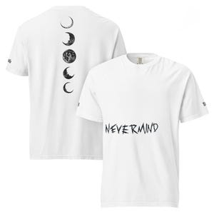 Puede incluir: Camisetas blancas con gráficos negros. Una camiseta presenta la palabra "NEVERMIND" en un estilo manuscrito. La otra camiseta tiene un diseño vertical de fases lunares en la espalda. Ambas camisetas tienen mangas cortas.