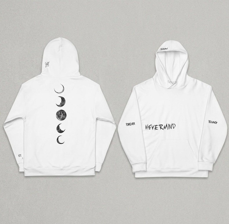 May include: White hoodie with a front pocket and a hood. The back of the hoodie features a series of moon phases. The front of the hoodie has the word "NEVERMIND" in a handwritten style, with "FOREVER" and "YOUNG" on the sleeves.