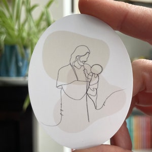 Puede incluir: Un dibujo lineal de una persona sosteniendo a un niño. El dibujo está en blanco y negro y sobre un fondo blanco con una acuarela beige y marrón claro.