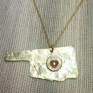 oklahoma hand cut out of brass and hand hammered .357 recycled casing I actually shot red crystal heart bling in center