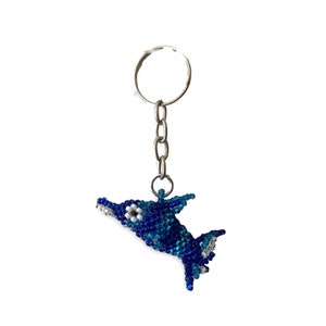 May include: A blue and white beaded dolphin keychain with a silver chain.