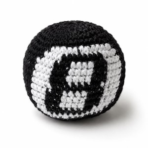 Peut inclure: Une balle crochet&eacute;e noire et blanche, ressemblant &agrave; une boule de billard num&eacute;ro huit. La balle est ronde avec un fond noir et un motif de huit blanc. La texture crochet&eacute;e est visible, sur fond blanc.