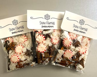May include: Three clear plastic pouches containing stovetop potpourri with red and white peppermint candies, star anise, cinnamon sticks, and white shavings. Each pouch has a white header card printed with a snowflake and the text Snow Flurries.