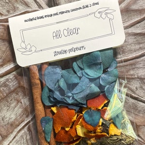 May include: A clear plastic bag filled with eucalyptus leaves, orange peel, rosemary, cinnamon sticks, and cloves. The bag has a label that reads "All Clear Stovetop Potpourri".