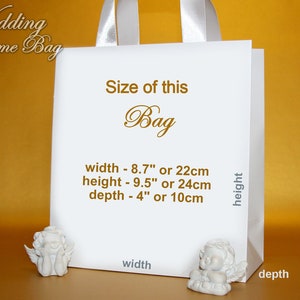 May include: White wedding welcome bag with a satin handle. The bag is decorated with gold text that reads "Size of this Bag" and lists the dimensions: width - 8.7" or 22cm, height - 9.5" or 24cm, depth - 4" or 10cm.