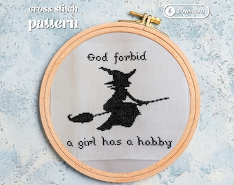 Puede incluir: Patrón de punto de cruz en un bastidor de madera con la silueta negra de una bruja en una escoba. El texto dice "God forbid a girl has a hobby". El fondo es un patrón azul claro y blanco.