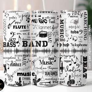 May include: Three white tumblers with a musical theme. The tumblers are covered in black text and graphics of musical instruments, notes, and words like "band," "music," and "jazz." The design includes a sound wave pattern.