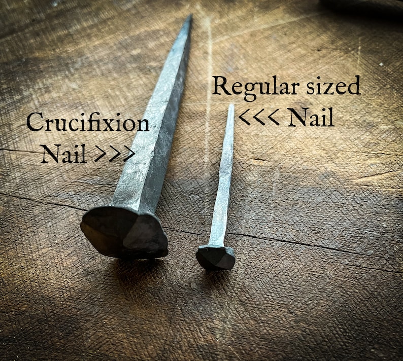 May include: Two metal nails, one labelled "Crucifixion Nail" and the other labelled "Regular sized Nail".