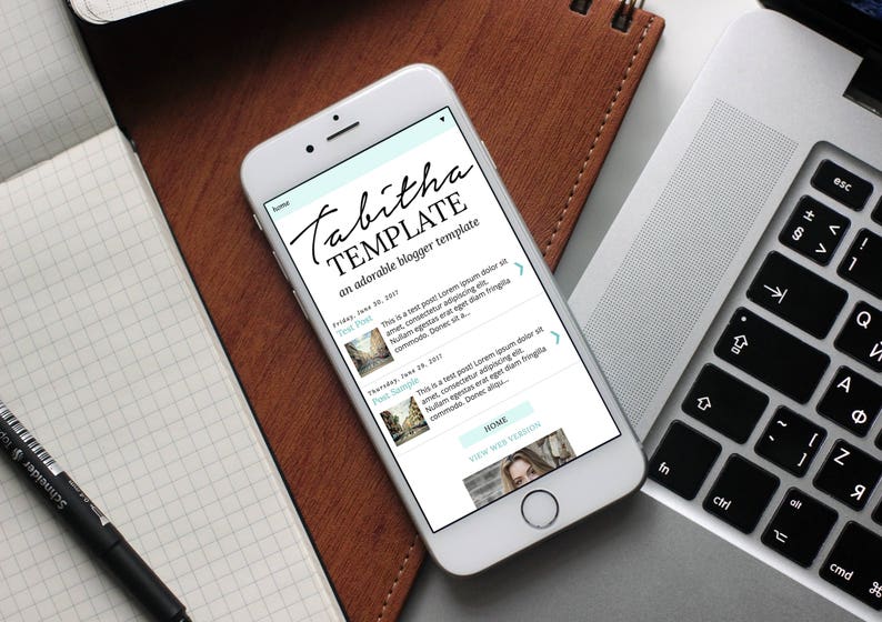 Puede incluir: Un tel&eacute;fono inteligente blanco que muestra una plantilla de sitio web llamada "Tabitha Template" con el texto "una plantilla de blog adorable". La plantilla de sitio web tiene un fondo azul claro con texto blanco e im&aacute;genes. La plantilla de sitio web tiene un bot&oacute;n de inicio y un bot&oacute;n de ver sitio web.