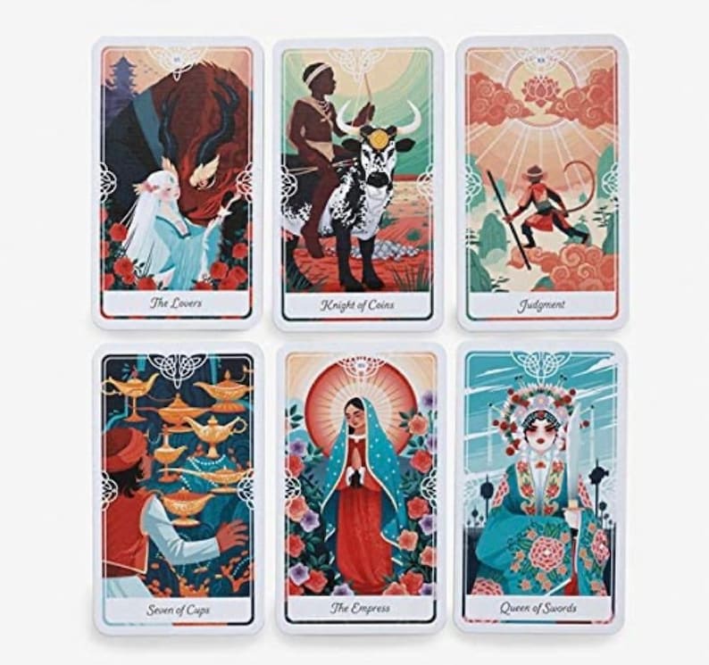 A person using The Divine Tarot for a tarot spread, with cards laid out on a table