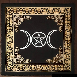Può includere: Tovaglia da altare in velluto nero con un bordo di nodo celtico dorato e un design di tripla luna e pentagramma bianco.
