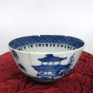 Puede incluir: Un cuenco de porcelana azul y blanco con un diseño chino. El cuenco tiene una grieta en el lateral.