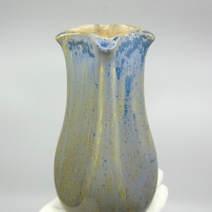 May include: A small, blue and gold ceramic vase with a unique, textured glaze.