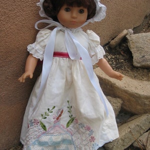 Long white dress with pillowcase embroidery trim.