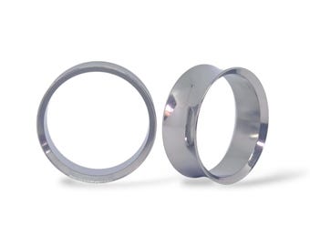 May include: Two polished, silver-colored ear gauges. One is a simple ring, and the other has a flared design. The gauges are displayed on a white background, showcasing their smooth, reflective surfaces.