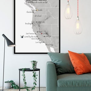 Peut inclure: Une carte encadr&eacute;e de la c&ocirc;te ouest des &Eacute;tats-Unis avec un fond en marbre gris. La carte montre un itin&eacute;raire avec des arr&ecirc;ts &agrave; Seattle, Portland, Crater Lake, Brookings, San Francisco, Carmel-by-the-Sea, Morro Bay, Dixon, Yosemite, Lone Pine, Los Angeles et San Diego. Le texte "WEST COAST USA 2019" et "Not all those who wander are lost" est en haut de la carte.
