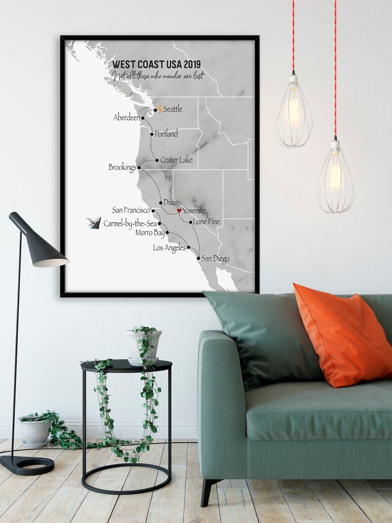 Peut inclure: Une carte encadr&eacute;e de la c&ocirc;te ouest des &Eacute;tats-Unis avec un fond en marbre gris. La carte montre un itin&eacute;raire avec des arr&ecirc;ts &agrave; Seattle, Portland, Crater Lake, Brookings, San Francisco, Carmel-by-the-Sea, Morro Bay, Dixon, Yosemite, Lone Pine, Los Angeles et San Diego. Le texte "WEST COAST USA 2019" et "Not all those who wander are lost" est en haut de la carte.