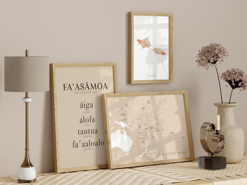 May include: Three framed prints on a wooden table with a lamp and a decorative sculpture. The prints are of a map of Samoa, a map of the South Pacific, and a text-based print with the words "Fa'asamoa The Samoan Way" and Samoan words for family, love, service, and respect.