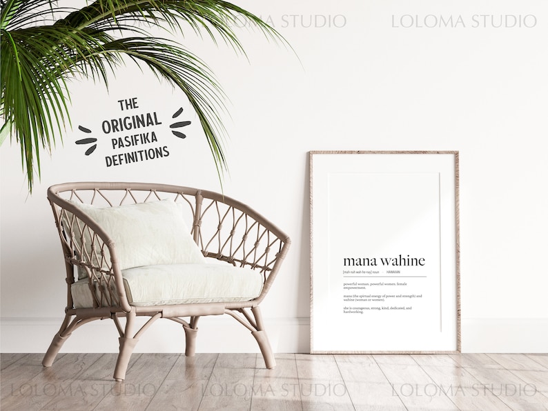 May include: A framed print with the text "mana wahine" and a definition of the word in English. The print is hanging on a white wall in a room with a wicker chair and a potted plant.