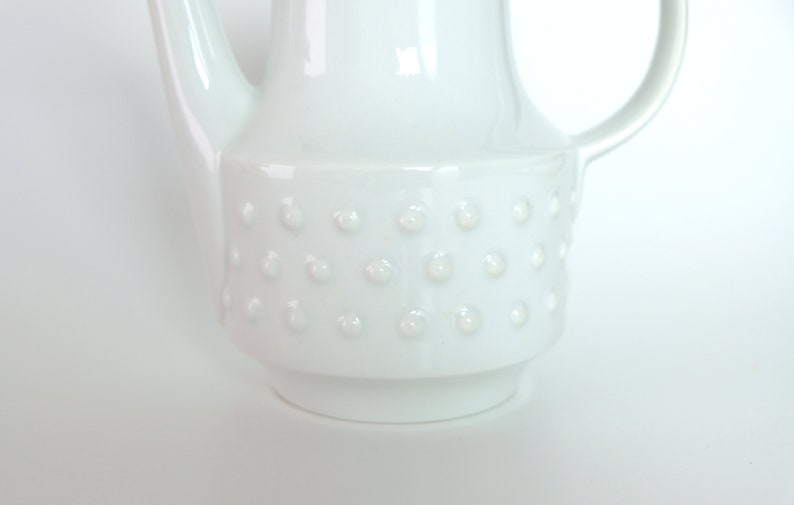 May include: White ceramic teapot with a textured, dotted design around the body.