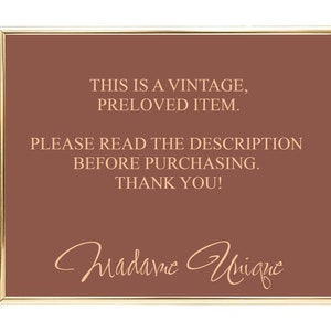 May include: A brown sign with gold trim, reading "This is a vintage, preloved item. Please read the description before purchasing. Thank you!" with the signature "Madame Unique" in cursive.