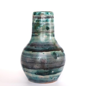 Könnte beinhalten: Eine handgefertigte Keramikvase mit bauchigem Körper und schlankem Hals. Die Vase hat eine strukturierte Oberfläche mit horizontalen Bändern in Türkis, Grau und Dunkelblau. Die Vase ist etwa 20 cm hoch.
