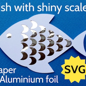 May include: A white paper fish with silver foil scales. The fish is on a blue background. The text "Fish with shiny scales" is at the top of the image. The text "Paper + Aluminium foil" is at the bottom left of the image. The text "SVG" is in a yellow starburst at the bottom right of the image.